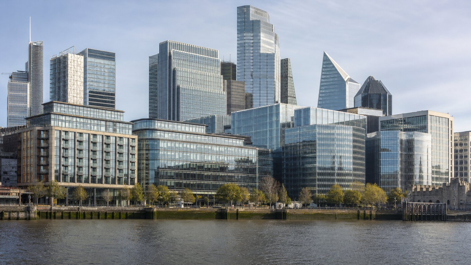 A riverfront financial district with modern office towers in clear daylight